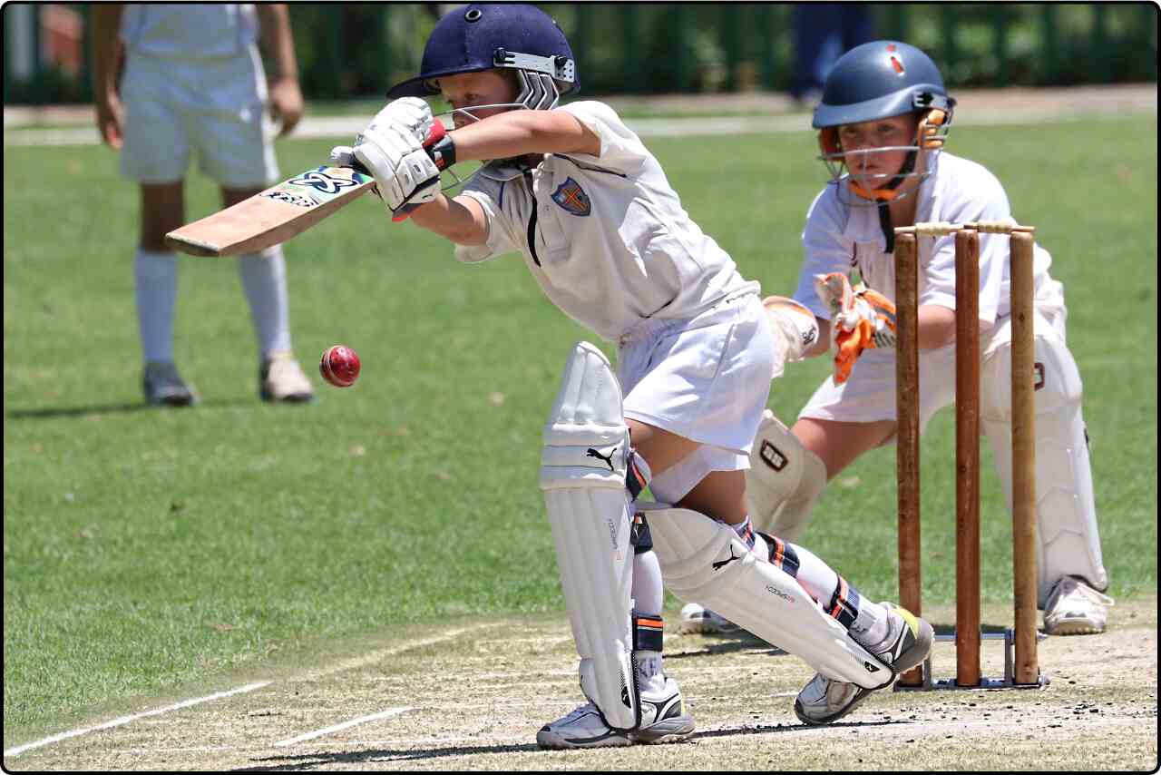 Children playing cricket with enthusiasm on a sunny day.